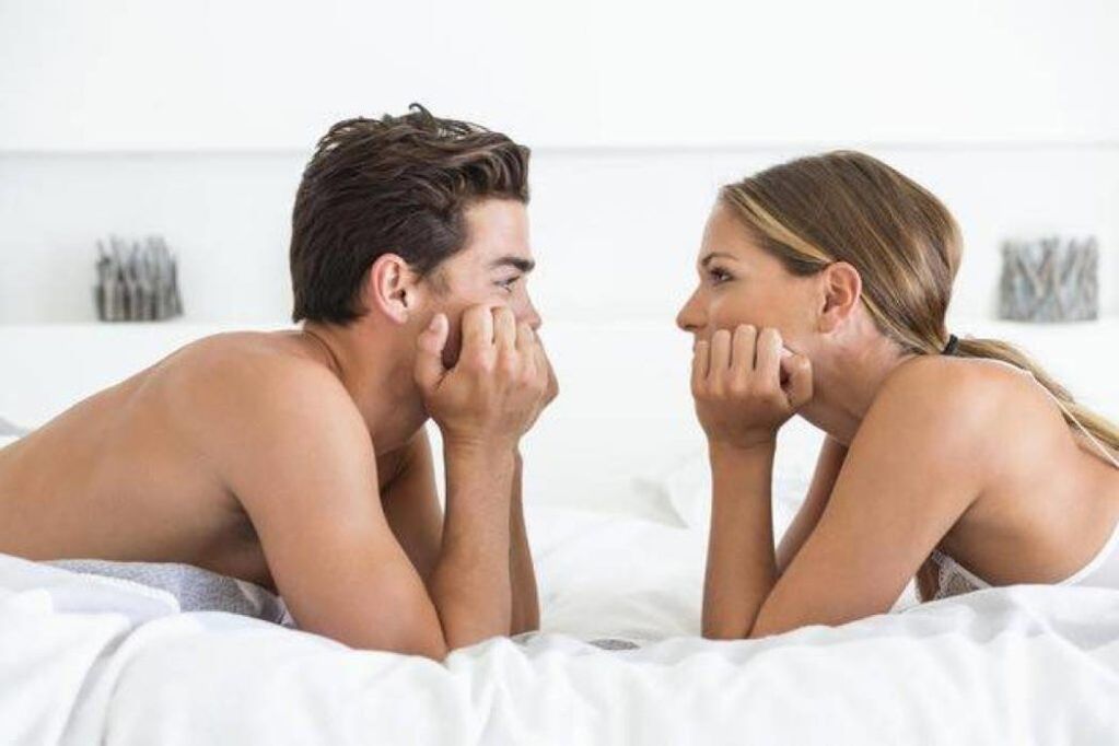 A woman and a man with an enlarged penis in bed