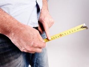 A man measures the length of his penis before increasing his penis with soda